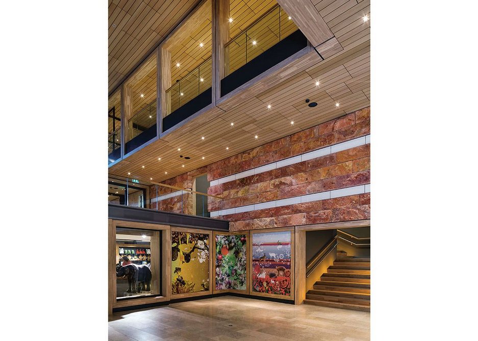 Red travertine, concrete art frieze, limestone floors, timber soffits and treads, Tord Boontje murals; everything is thrown at the visitor at ground floor level.