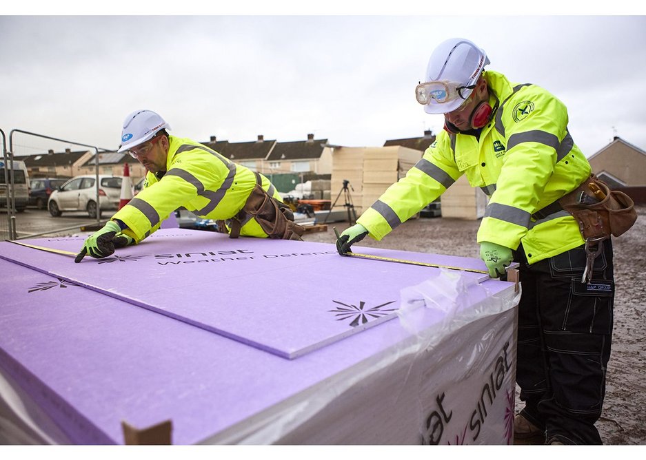 Two installers cutting Weather Defence board to size on site at the new school in Wales.