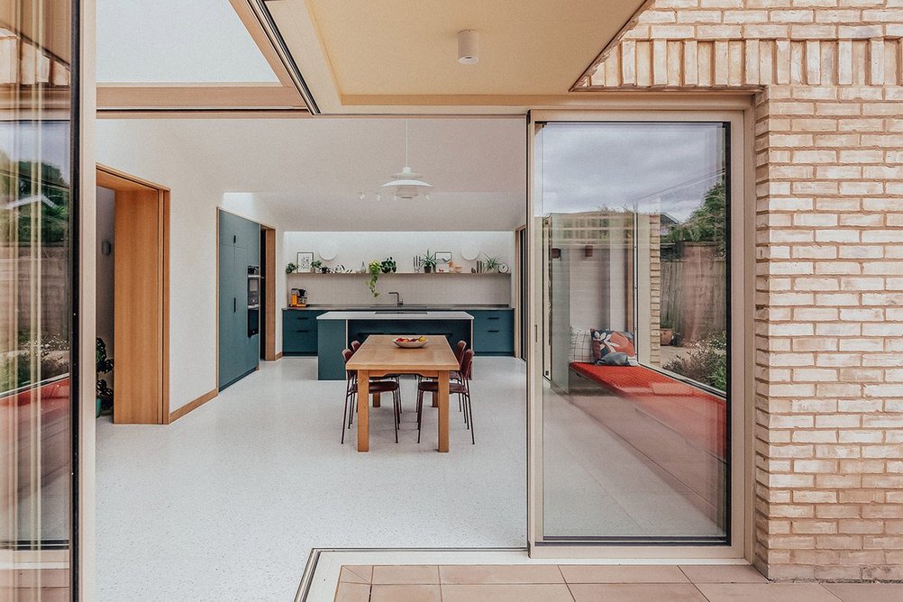 Large sliding glass doors connect the house and garden.