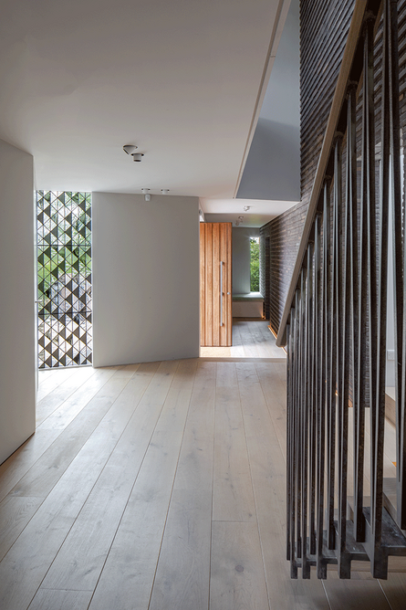 Looking back towards the front door in the hall. To the left is the bottom half of the stained glass window with its triangular design and smoked panels.