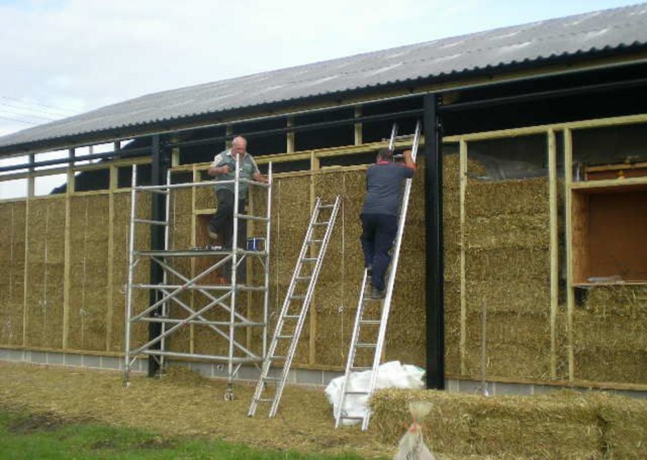 The straw bale walls going up under the steel frame agricultural structure.