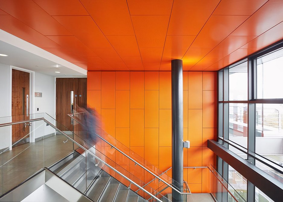Bright orange Armstrong R-H 200 perforated metal hook-on planks on the ceiling of the Wirral Waters Kingsgate office building, Birkenhead.
