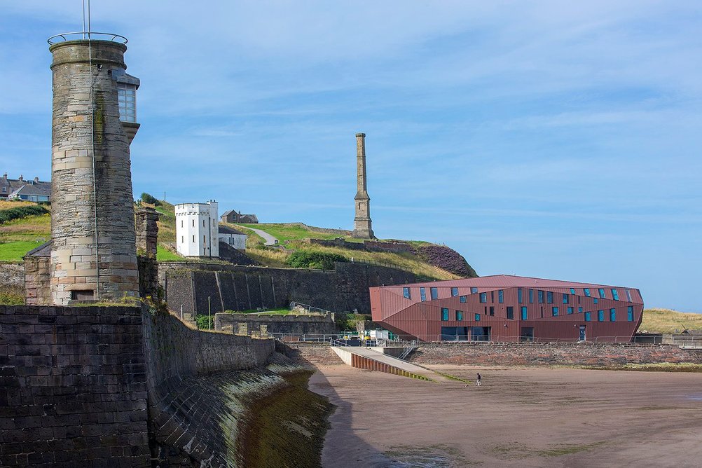 VM Zinc's Pigmento red standing-seam panels entirely wrap the three-storey Edge activities centre in Whitehaven, Cumbria, by Northmill Associates.