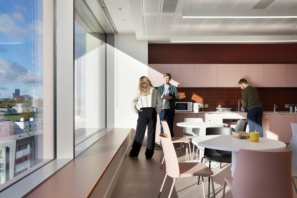 Kitchens feature terracotta-coloured tiles and pink units.