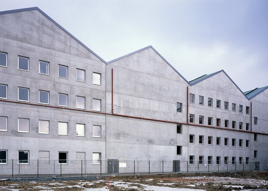The rear of the new school is constructed from white concrete to signify where the image of the factory has been cut and changed.