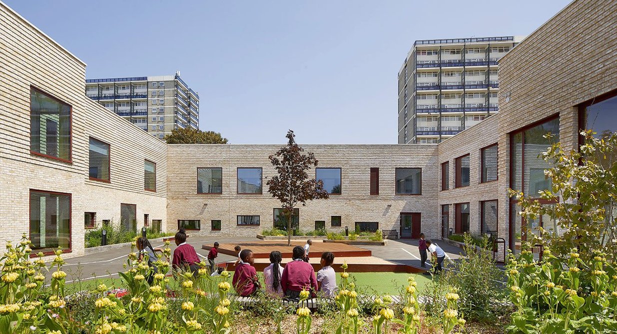 Two-storey wings surround three-sided courtyard designed for open-air teaching.