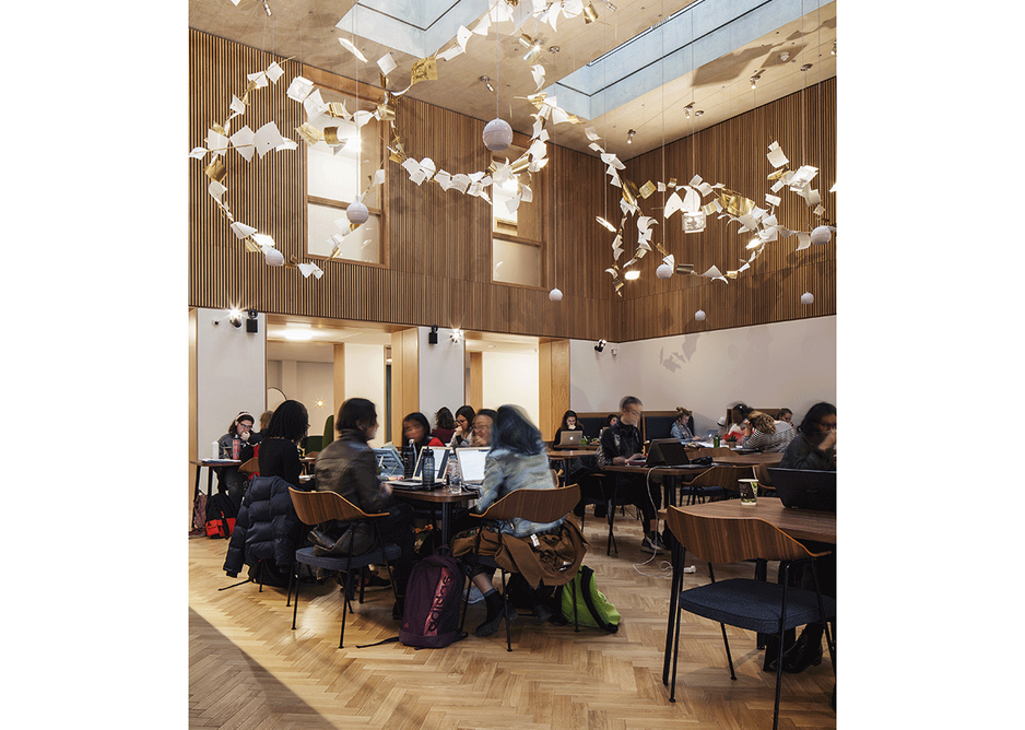 The double height central dining hall with its strange chandelier sculpture is looked down upon by the residential corridors above.