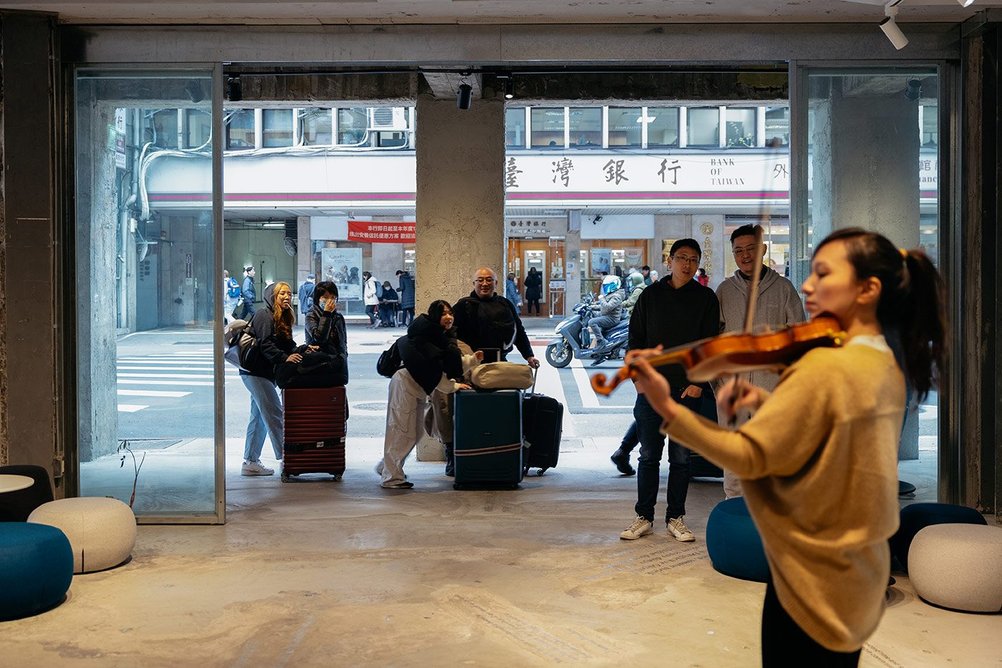 The ground floor is used as a public space where anything can happen, including here busking.