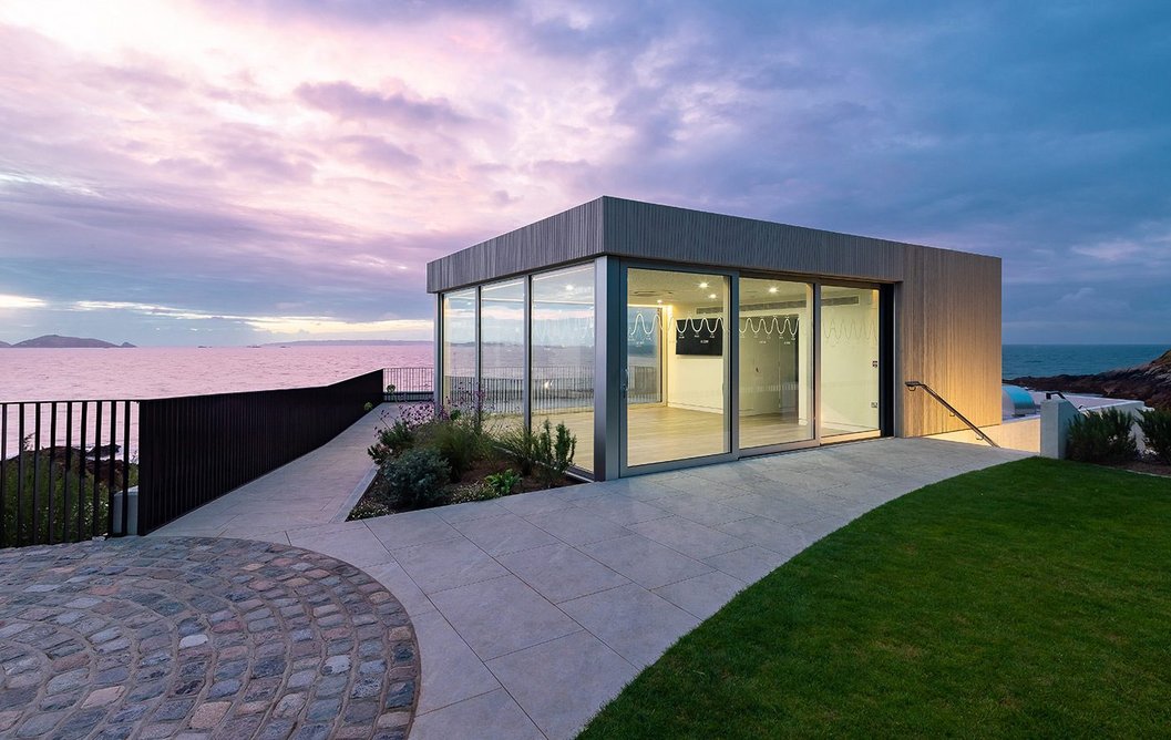 The community pavilion at night within its landscaped setting, accessed internally but also externally by a separate outdoor stair to give flexibility.