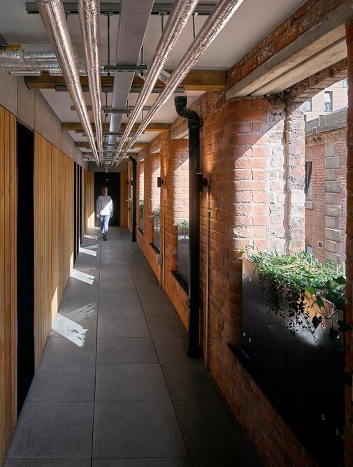Derelict warehouses were renovated for residential use by shedkm, preserving industrial fabric including cast-iron columns and external stairs.