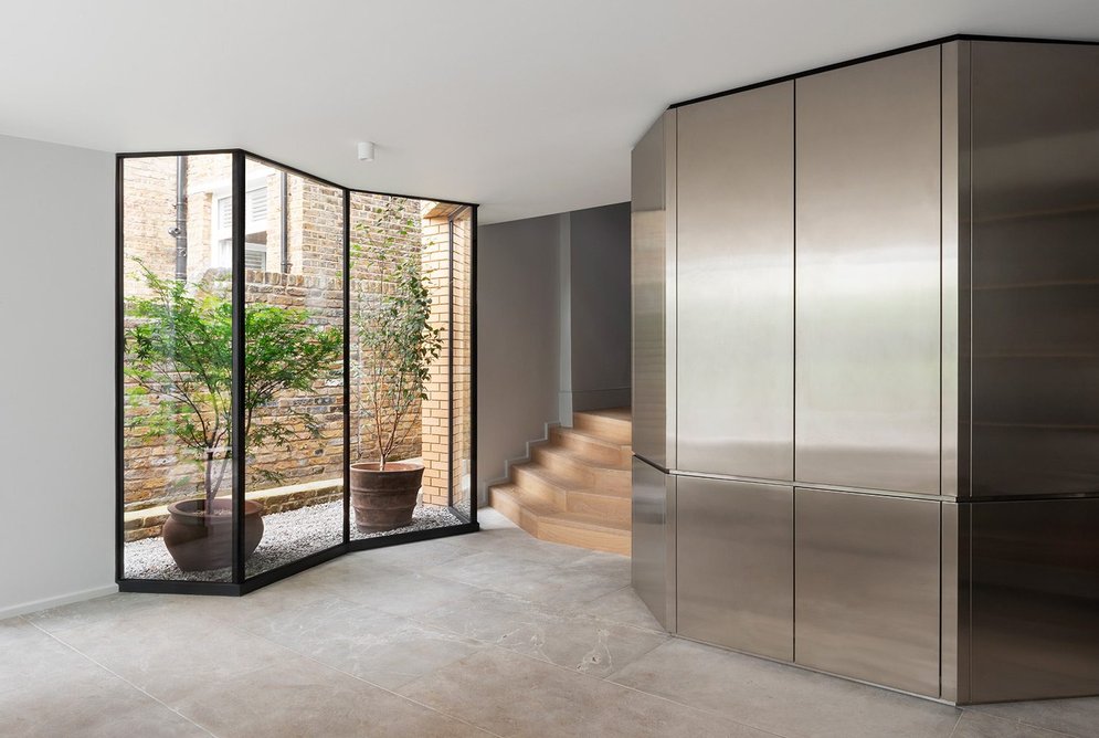 A solid stainless-steel volume conceals storage and a cloakroom.