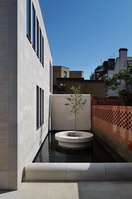 Circular motifs recur in  pale precast concrete  elements in the garden of reflection.