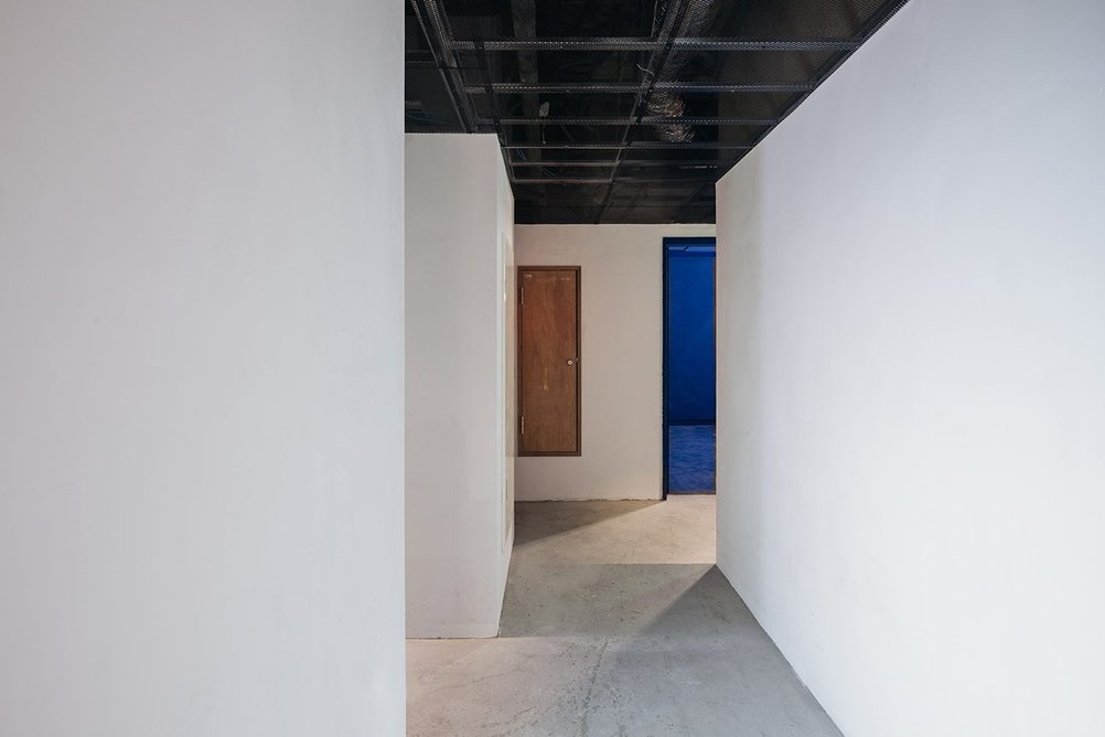 Another bedroom corridor at The Blue with white walls and grey floors.