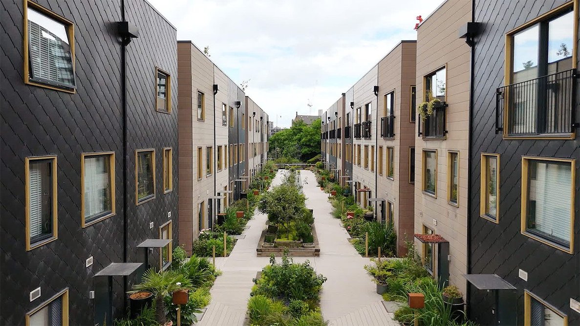 Planted communal areas run between townhouse blocks.