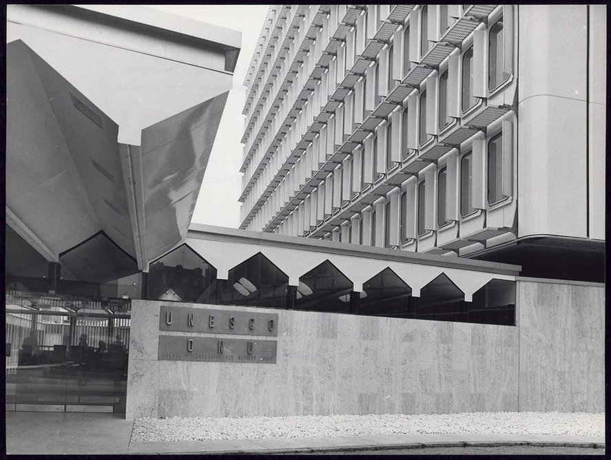 External view of the Toblerone steel roof structure and travertine wall of the entrance hall area with offices above.