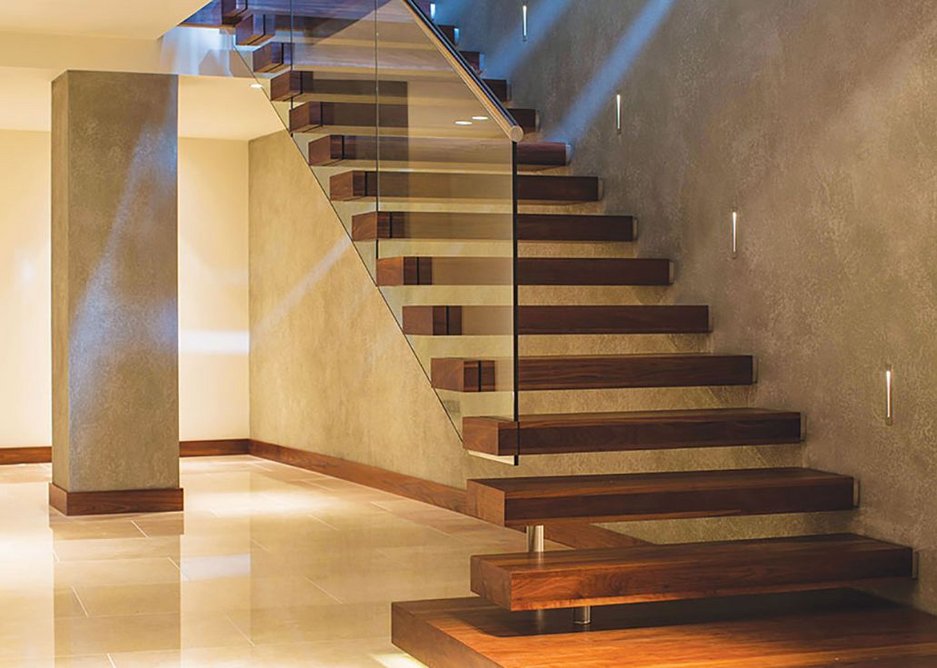 Walnut cantilever ‘floating’ staircase with glass balustrade and stainless steel handrail.