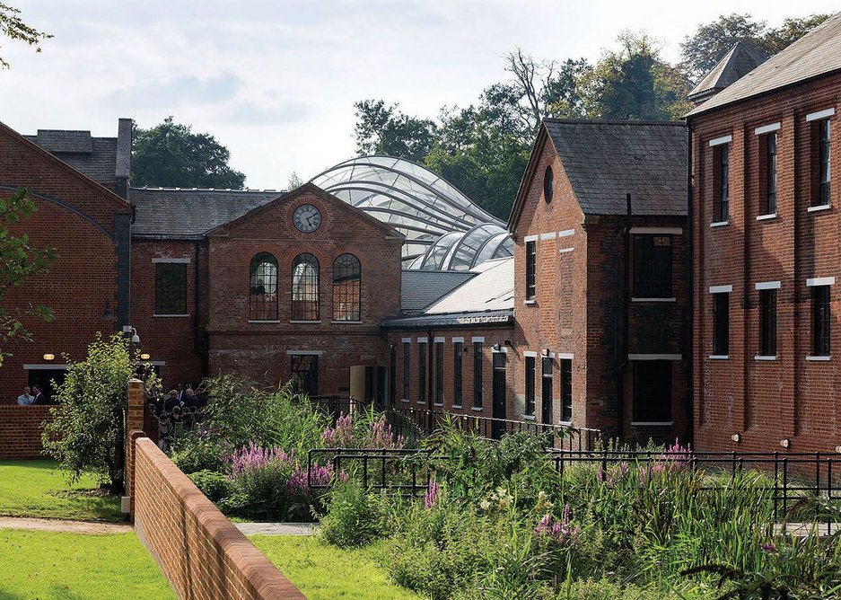 The distillery complex looking west, the curved geometry of the glass houses appearing above the original rooftops