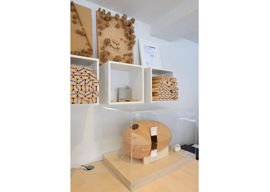 Models and rolls of drawings displayed on the shelves at PAD Studio.