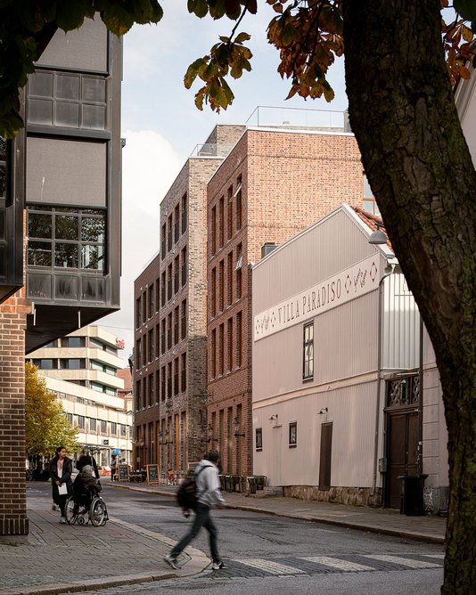 View from the main road shows the new passageway between the left and right brick buildings.