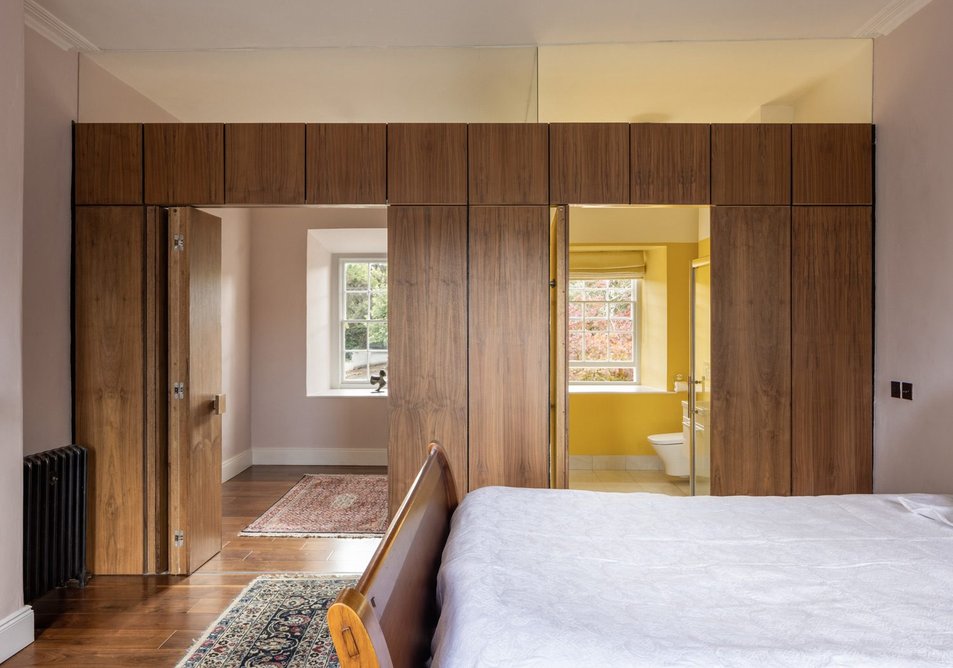 A walnut screen wall divides the main bedroom from the ensuite bathroom and walk-in wardrobe.
