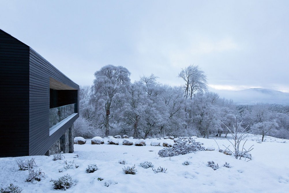 The extension is clad at upper level with black-painted Siberian larch and local stone below.