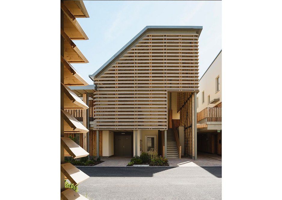 A louvred entrance to the upper level flats which contains essentials like platform lift, staircase and post boxes.