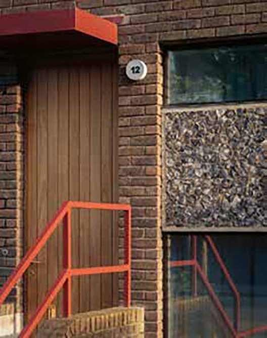 Entrance, with new red metal front door canopy and napped flint panels.