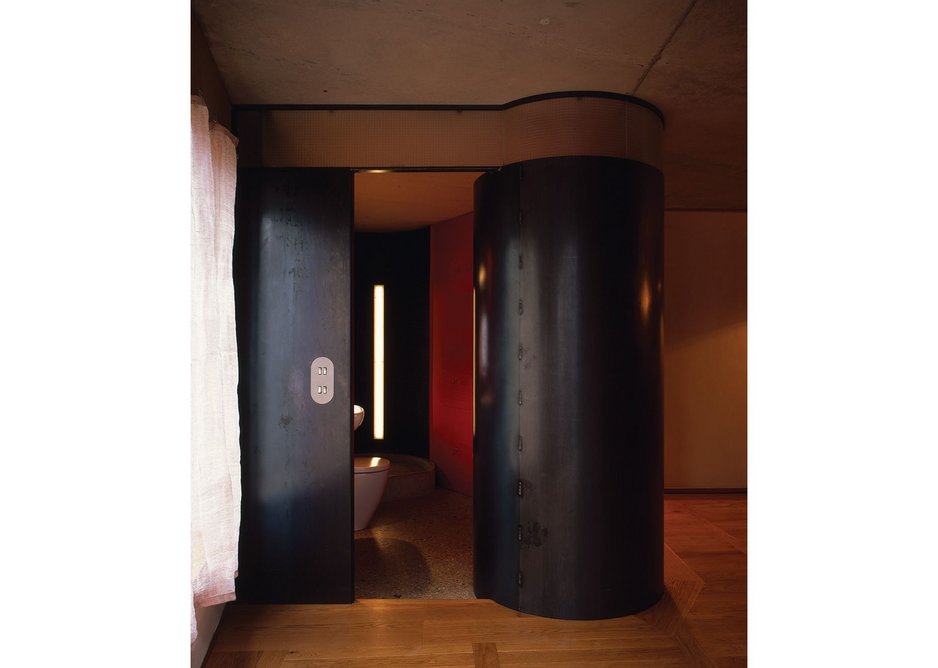 Bathrooms are discrete pod ‘mechanisms’ formed of a cavity wall of sheet steel, painted in ‘reactive colours’ that respond immediately to light and dark.