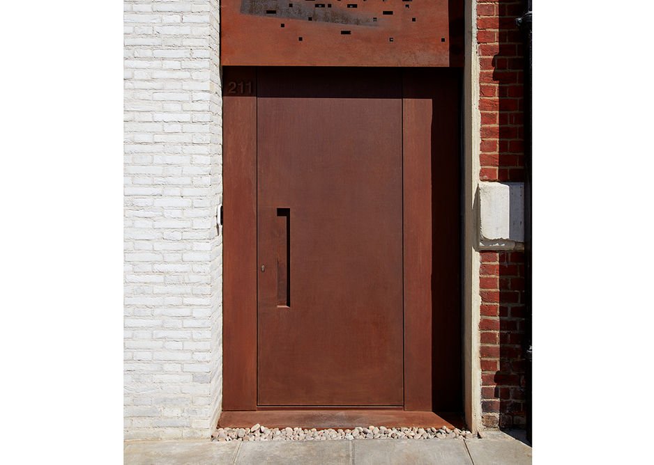 Urban Front Raw e90 steel doorset in Rust with concealed handle and matching panels to the side.