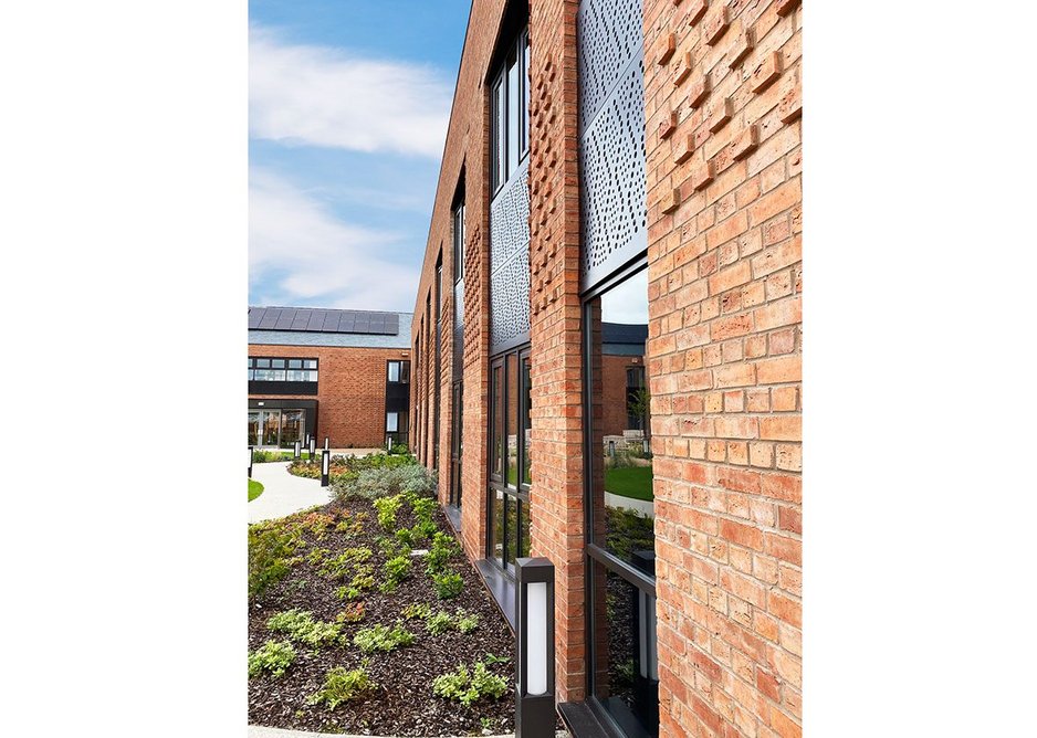 Care centre courtyard – perforated bronze panels take their patterns from original hosiery machine punch cards. Credit Glancy Nicholls Architects