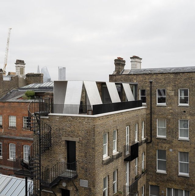 Remodelling a former merchant's house's upper floors, Carmody Groarke put living space at the top and added an aluminium pavilion