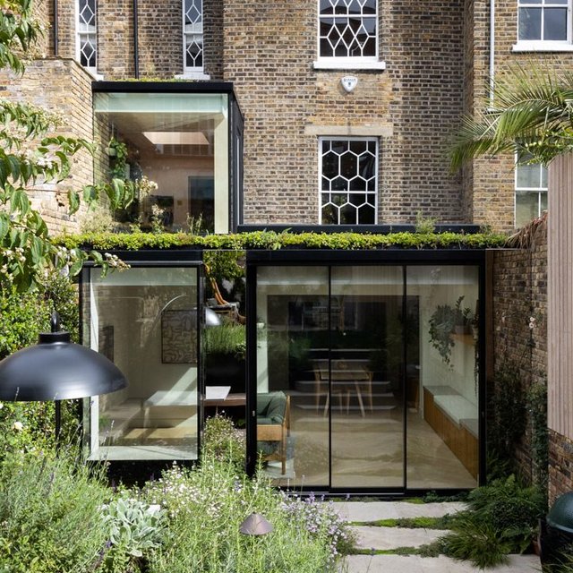 Stainless steel panels and an oriel window set up a subtle intimacy between house and garden