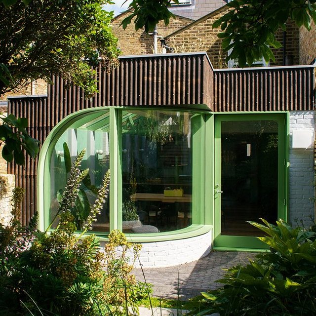 CAN’s extension features an open-plan kitchen that spills into the garden through a curved window