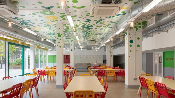 The hand-painted ceiling mural extends over the teaching kitchen at one end of the dining room.