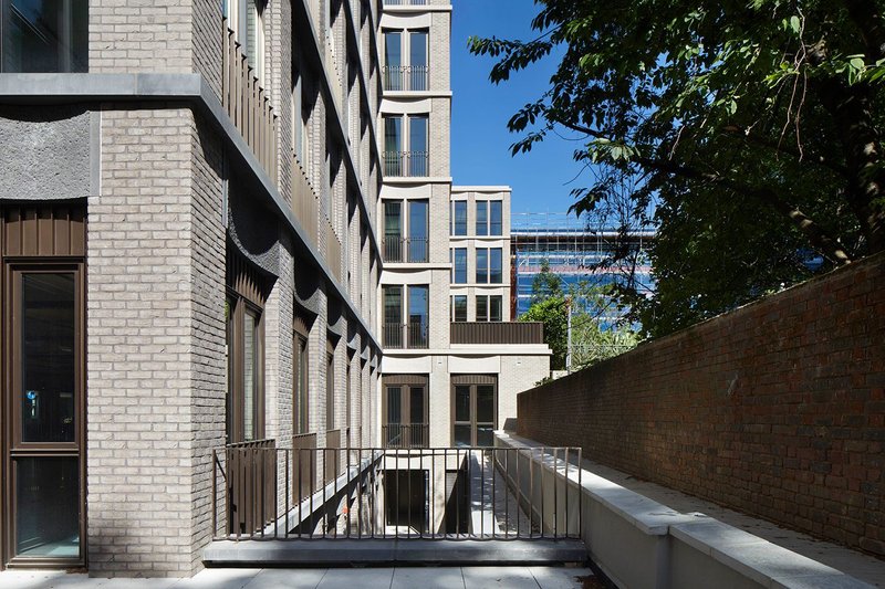 Morris+Company’s unitised brick facades steps down to the walls of the ancient cemetery adjacent.