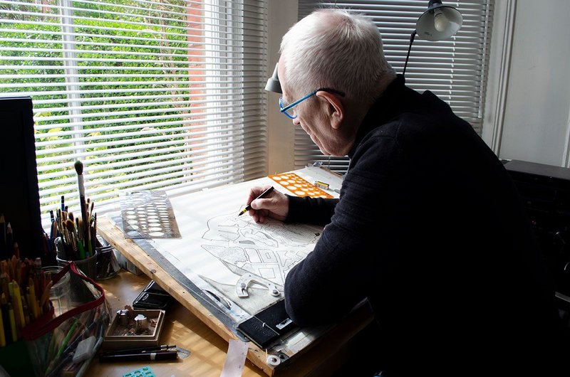 Peter Cook at his drawing board in the bay window of his front room.