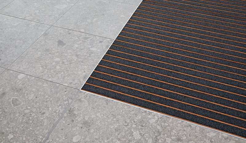 Intrasystems' Intraform DM 12mm low profile entrance matting with wood effect profiles and recycled nylon inserts. For surface mounted or shallow recessed applications.
