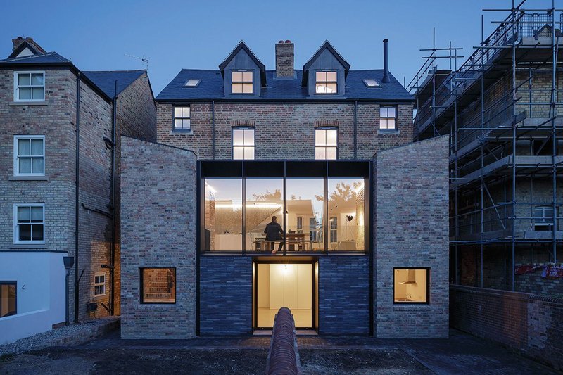 The garden elevation extends both houses’ rear extensions and builds between them to form one of striking, postmodern symmetry.