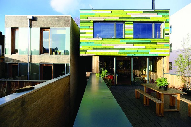 Rear elevation, with second storey clad in Woods’ colourful timber panelling, and first floor external terrace.