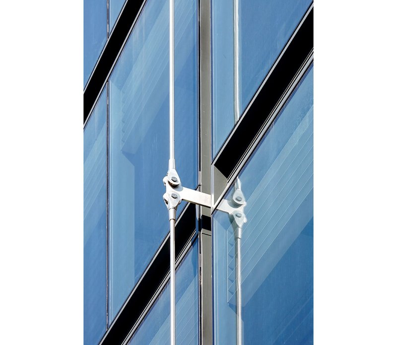 Stainless steel support arms accommodate building movement and allow the facade to move independently of the existing building.