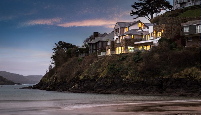 The three-storey dwelling in Salcombe, Devon replaced an existing no-frills seaside lodge. The build faced logistical challenges, including a cliffside site and single track road access.