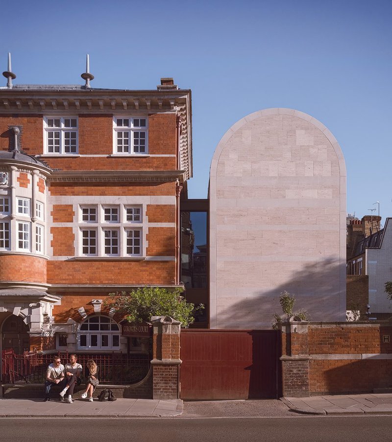 A glass collar divides  the existing building  from the extension.