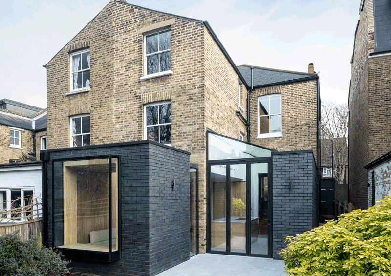 The new extensions are built in a dark charcoal brick, creating a new/old contrast with the London stock.