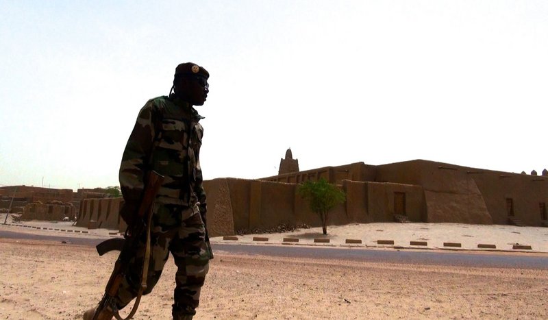 A soldier patrols in front of Djinguereber Mosque, Timbuktu.
