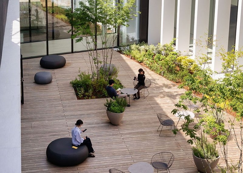 The outdoor courtyard at Sigma's head office in Kawasaki, Japan is designed in dialogue with the surrounding natural environment. Furnishings are from Arper’s Leaf and Pix collections.