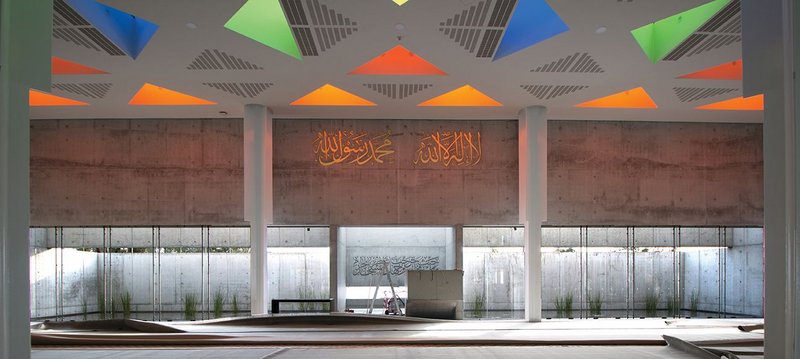 The main concrete wall, orientated to Mecca, with a calming reflective pool creating more subtle reflections on the dramatic ceiling.