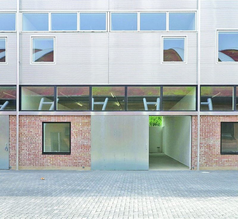 A string of clerestories gives artists even light while smaller windows open on the Royal Opera House’s production workshops opposite. Aluminium and brick give the building a reflective quality.