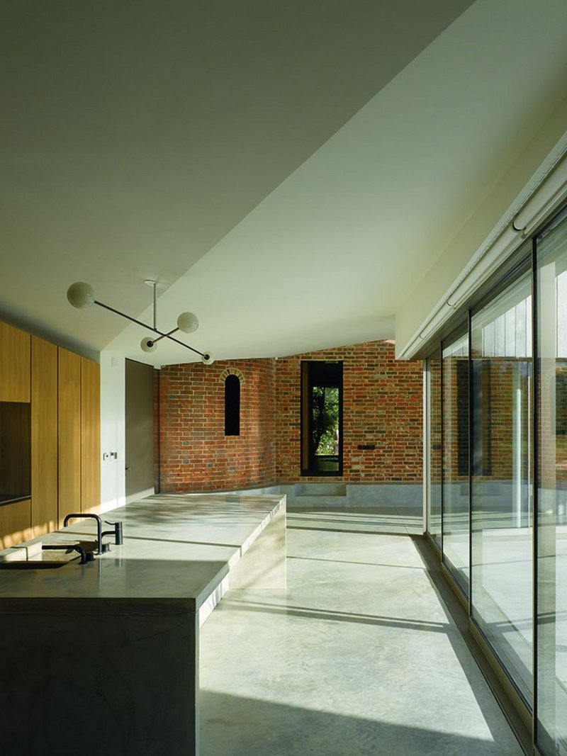 ‘Kitchen’ in the day room. Beyond, the concrete datum hints at how it has been dug into the ground in deference to the old barn and oast houses with their brick walls. The main entrance is to the far left.