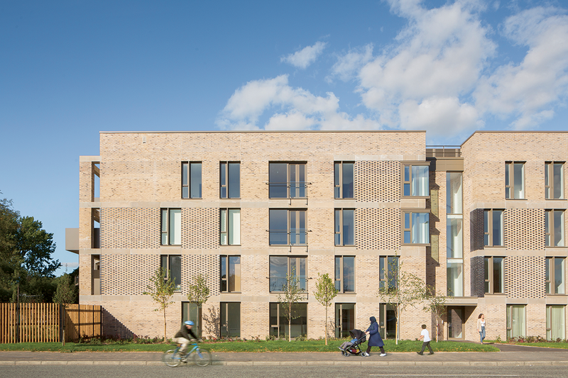 Max Fordham’s services design at Baker Place in Manchester city centre with OMI Architects is based around a low temperature community heating network using roof-mounted air source heat pumps as the heat source. Heat is distributed to apartments where it is used to provide space heating and domestic hot water. The air source heat pump in louvred enclosure on the roof is just visible.