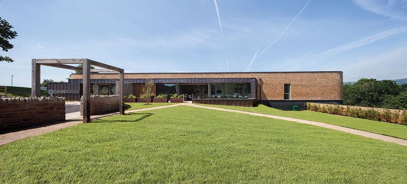 View of St David’s new inpatient unit from the outpatient building. The café and entrance, clad in copper, step forward from the main elevation, which is primarily clad in red cedar shingles.